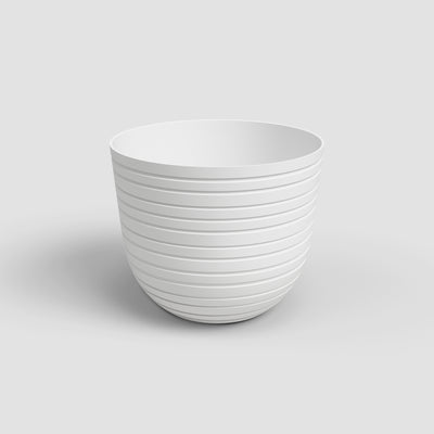 White ceramic planter with ribbed texture on a light gray background