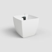 White geometric planter with a black interior on a light gray background