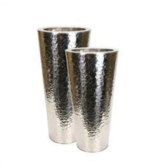 Two silver hammered metal tumblers on a white background