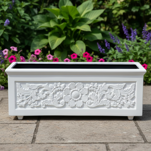 Decorative white planter with floral patterns on a stone surface with flowers in the background