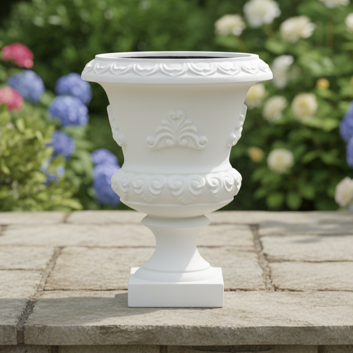 Decorative white urn on a stone surface with flowers in the background