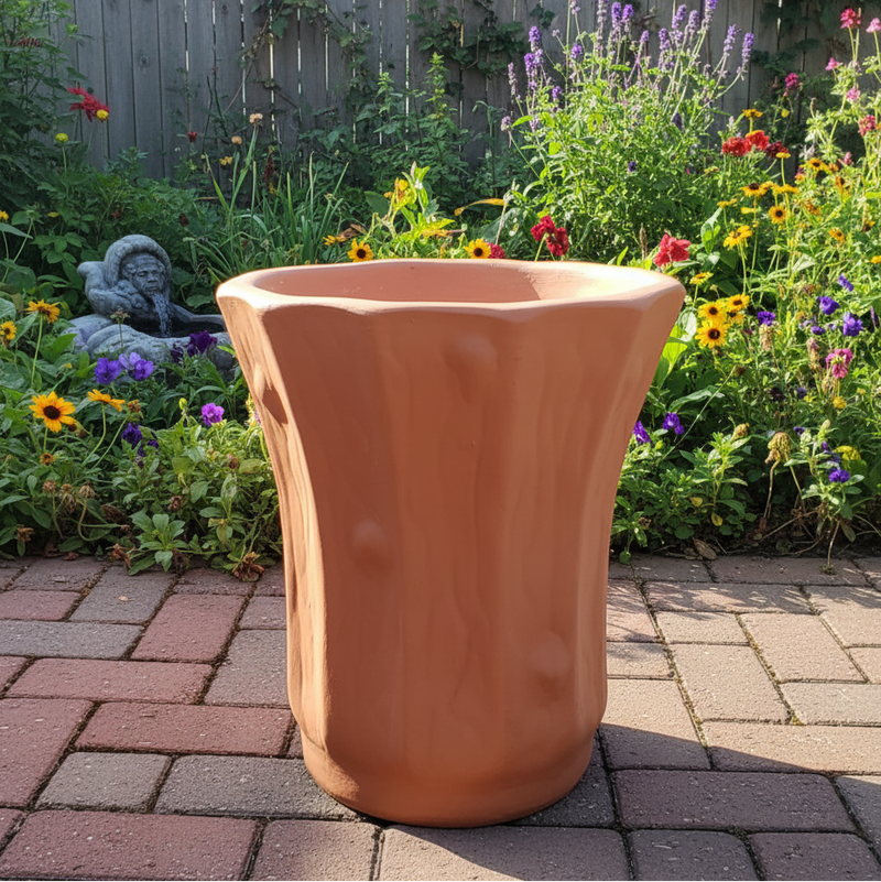 Terracotta planter on a patio with a garden in the background